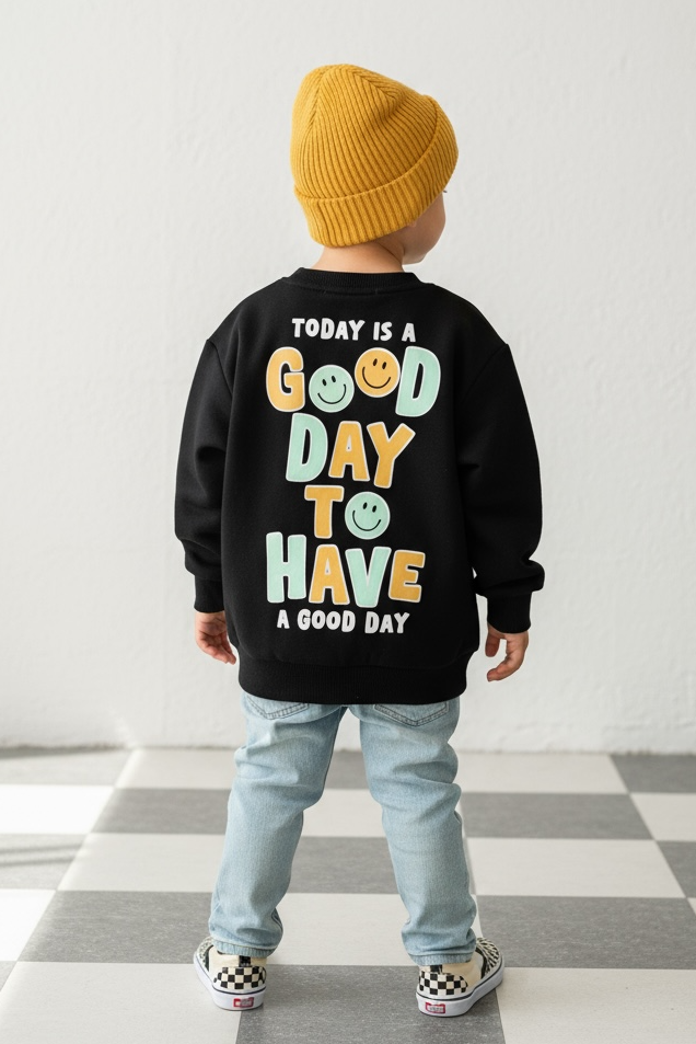 Child wearing a black sweatshirt with colorful text on a checkered floor.